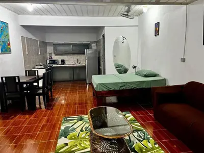 a living room with a table and a kitchen at Yireth Studio in Quepos
