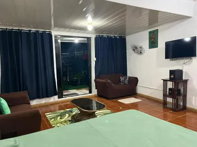a living room with two couches and a tv at Yireth Studio in Quepos