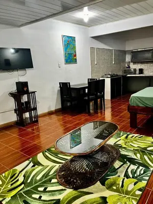 a living room with a glass table on a wooden floor at Yireth Studio in Quepos
