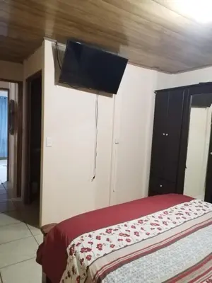 a bedroom with a bed with a television on the wall at La posada Escondida in Morazán