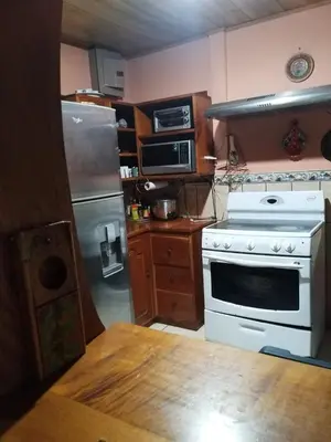 a kitchen with a white stove and a refrigerator at La posada Escondida in Morazán