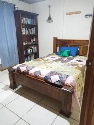 a bed in a room with a book shelf at La posada Escondida in Morazán