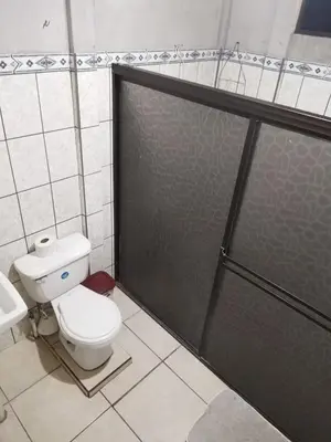 a bathroom with a toilet and a glass shower door at La posada Escondida in Morazán