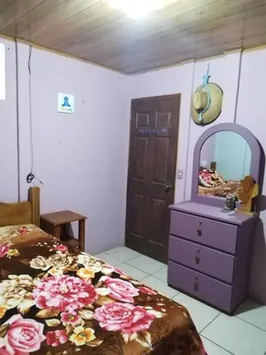 a bedroom with a bed and a dresser and a mirror at La posada Escondida in Morazán