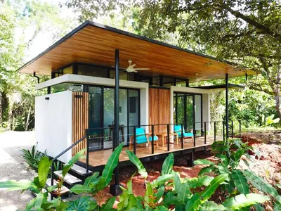 a small house with a wrap around porch at Casita Jungle Nest, 5 minutes drive to Playa Linda, 15 to Dominical, Wifi Starlink in Matapalo