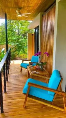 a porch with blue chairs and a wooden table at Casita Jungle Nest, 5 minutes drive to Playa Linda, 15 to Dominical, Wifi Starlink in Matapalo