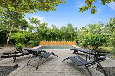 two lounge chairs and a pool in a yard at 4 BD Tranquil Villa in Playa Grande