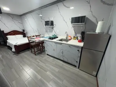 a kitchen with a sink and a refrigerator and a bed at Apartamento doña Lety in Fortuna