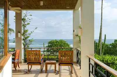 a porch with chairs and a view of the ocean at Casa Ohana - 5 BR Ocean Front Home in Playa Negra, CRC in Playa Negra