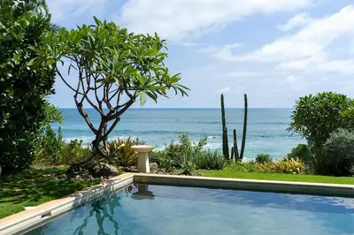 a swimming pool with the ocean in the background at Casa Ohana - 5 BR Ocean Front Home in Playa Negra, CRC in Playa Negra