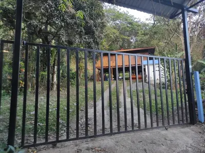 a black metal gate in front of a house at CASA CON PISCINA Montañas de San Ramón in San Ramón