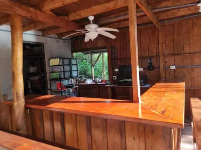 a kitchen with wooden walls and a ceiling fan at CASA CON PISCINA Montañas de San Ramón in San Ramón