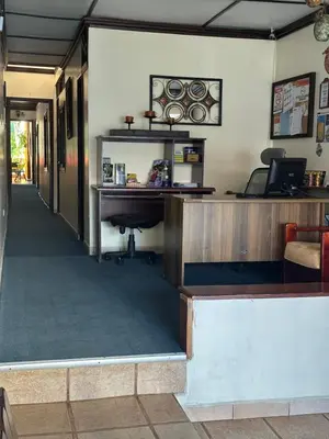 a lobby with a desk and a piano at Hotel Pacande B&B in Alajuela City