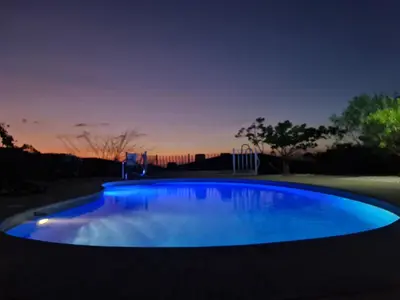 a large blue pool in a yard at night at Oceanic vista in Coco
