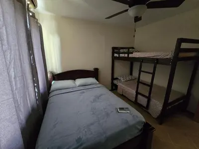 a bedroom with a bed and two bunk beds at Oceanic vista in Coco