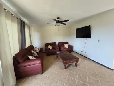 a living room with two couches and a flat screen tv at Oceanic vista in Coco
