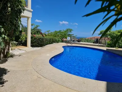 a blue swimming pool next to a house at Oceanic vista in Coco