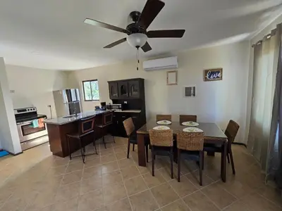 a kitchen and dining room with a table and a ceiling fan at Oceanic vista in Coco