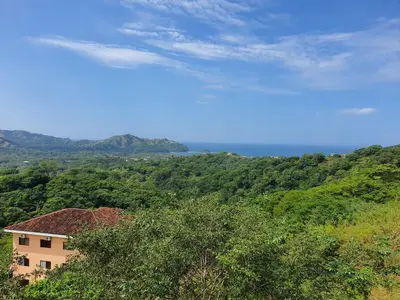 a house on top of a hill with trees at Oceanic vista in Coco