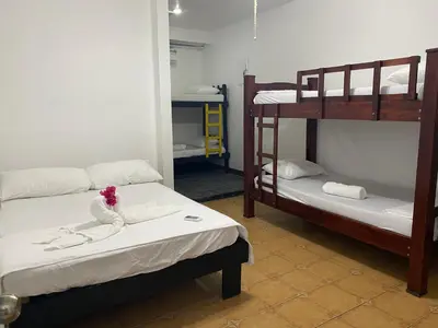 a room with two bunk beds in a room at La Hacienda Rooms & Food in Jacó
