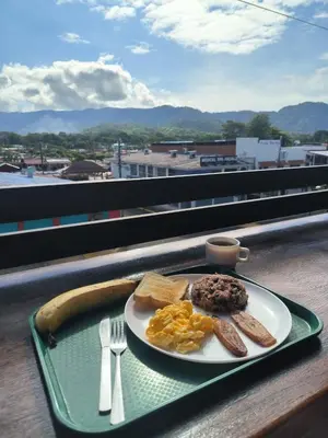 a plate of breakfast food on a tray on a table at La Hacienda Rooms & Food in Jacó