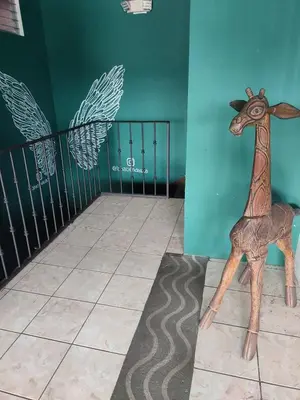 a wooden toy giraffe on the floor of a room at La Hacienda Rooms & Food in Jacó