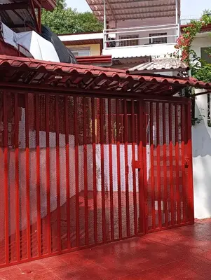 a red gate on the side of a house at Apartamentos Novoa in San José