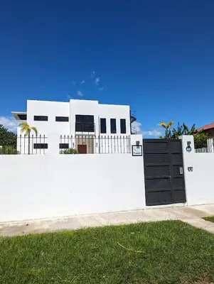 a white house with a gate and a fence at Casa Corales Dreams 2 in Playa Flamingo