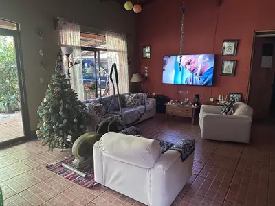 a living room with a christmas tree and a tv at Yellow House in Huacalillo