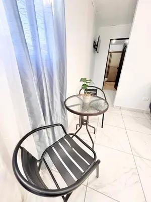 a table and chairs in a room with a window at Global House Apartamento 2 in Alajuela City