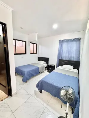 a bedroom with two beds and a fan in it at Global House Apartamento 2 in Alajuela City
