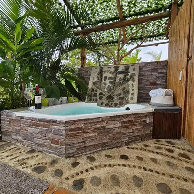 a jacuzzi tub sitting in a garden at Love Glamping Dome in El Hogar