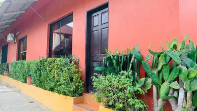 a red building with plants in front of a door at Hotel Cabinas Mar Y Cielo in Montezuma