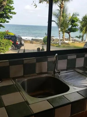 a kitchen sink with a window looking out at the ocean at Hotel Cabinas Mar Y Cielo in Montezuma