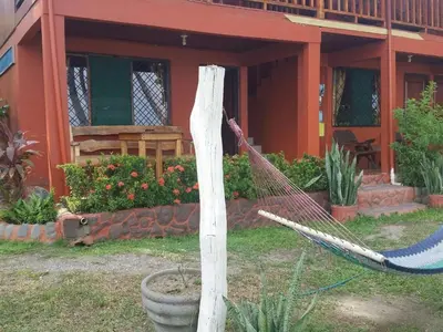 a hammock in front of a house at Hotel Cabinas Mar Y Cielo in Montezuma