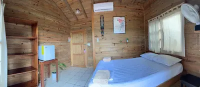 a bedroom with a bed in a wooden cabin at Blue Dream Kite Boarding Resort Costa Rica in Puerto Soley