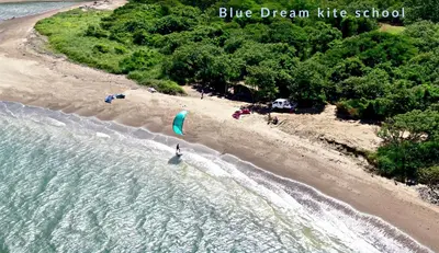 a person flying a kite on a beach at Blue Dream Kite Boarding Resort Costa Rica in Puerto Soley