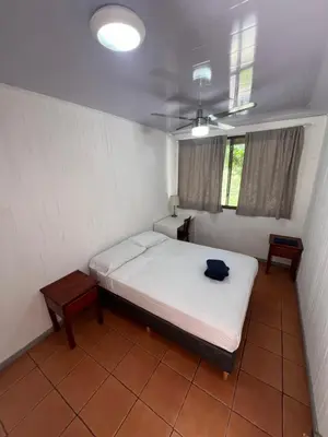 a bedroom with a bed and two tables in it at Blue Dream Kite Boarding Resort Costa Rica in Puerto Soley