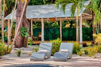 two chairs and a gazebo next to a pool at Casa Bonita - 5br With Pool Walk To Beach! in Nosara