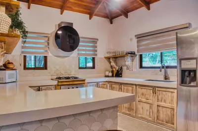 a kitchen with wooden cabinets and a large counter top at Casa Bonita - 5br With Pool Walk To Beach! in Nosara
