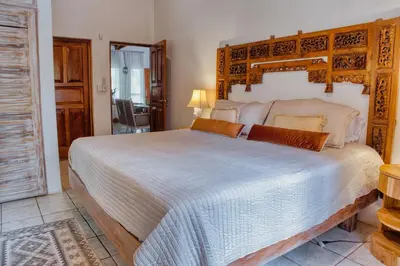 a bedroom with a large bed with a wooden headboard at Casa Bonita - 5br With Pool Walk To Beach! in Nosara