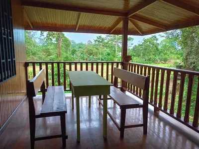 a porch with a table and chairs on a balcony at Casa corazón verde in Jiménez
