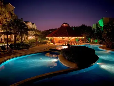 a swimming pool at a resort at night at Palmas Resort De Tamarindo Serenity Gem in Villarreal