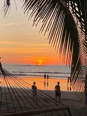 a group of people on the beach at sunset at Palmas Resort De Tamarindo Serenity Gem in Villarreal