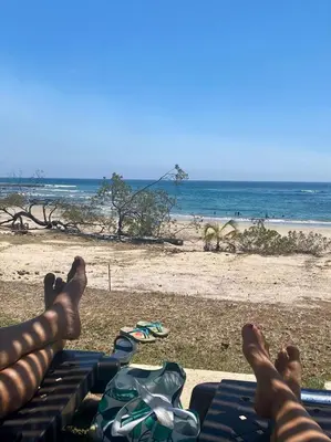 a person laying on a bench at the beach at Palmas Resort De Tamarindo Serenity Gem in Villarreal