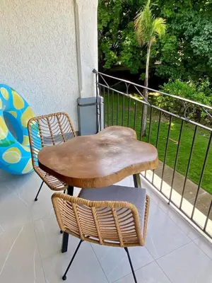 a wooden table and two chairs on a balcony at Palmas Resort De Tamarindo Serenity Gem in Villarreal