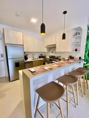a kitchen with a large island with bar stools at Palmas Resort De Tamarindo Serenity Gem in Villarreal