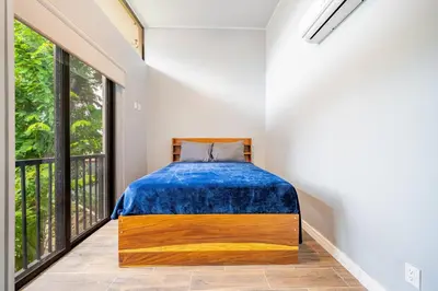 a bedroom with a bed and large windows at Monte Donato 18 - Apt 2 in Playa Avellana