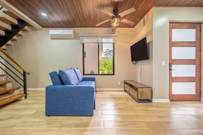 a living room with a blue couch and a ceiling fan at Monte Donato 18 - Apt 2 in Playa Avellana