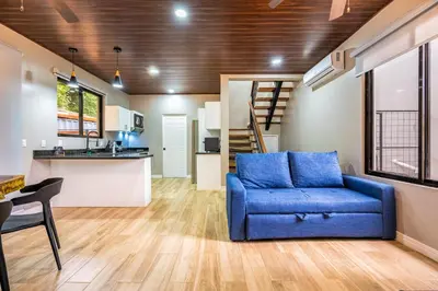 a living room with a blue couch and a kitchen at Monte Donato 18 - Apt 2 in Playa Avellana